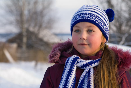 little girl is in a dark blue scarf and capの写真素材