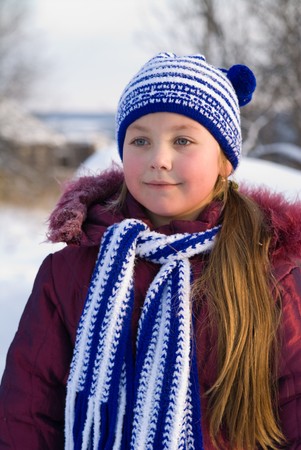 little girl is in a dark blue scarf and capの写真素材