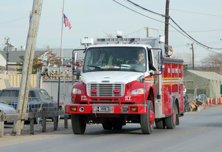 BREEZY POINT, NY - NOVEMBER 20: Firefighters moving into devastated area  in the aftermath of Hurricane Sandy on November 20, 2012 in Breezy Point, NYのeditorial素材