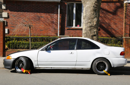 BROOKLYN,NEW YORK - MARCH 5: Two wheel locks on an illegally parked car in Brooklyn, NY on March 5, 2013. NYC started wheel lock program in January 2013.のeditorial素材