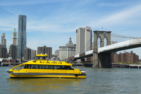 NEW YORK - APRIL 30: New York City Water Taxi with NYC skyline and Brooklyn Bridge seen from Brooklyn Bridge Park  on April 30, 2013. NYC Water Taxi has been servicing NYC commuters since 2002のeditorial素材