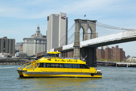 NEW YORK - APRIL 30: New York City Water Taxi under Brooklyn Bridge on April 30, 2013. NYC Water Taxi offering commuter and sightseeing service along the East River and Hudson River のeditorial素材