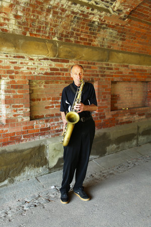 NEW YORK - JULY 18:Saxophone player performing under Central Park bridge in Manhattan on July 18, 2013.Central Park is designated a National Historic Landmark in 1962 was officially opened in 1857のeditorial素材