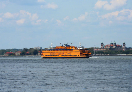 NEW YORK - AUGUST 17  Staten Island Ferry next to Ellis Island  in New York Harbor on August 17, 2013  Staten Island Ferry annually carries over 19 million passengers on a 5 2-mile or 8 4-km run のeditorial素材