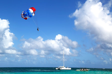 PUNTA CANA, DOMINICAN REPUBLIC - DECEMBER 31  Parasailing in a blue sky in Punta Cana on December 31, 2013  Parasailing is a popular recreational activity among tourists in Dominican Republicのeditorial素材