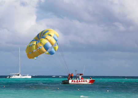 PUNTA CANA, DOMINICAN REPUBLIC - DECEMBER 31  Parasailing in a blue sky in Punta Cana on December 31, 2013  Parasailing is a popular recreational activity among tourists in Dominican Republic のeditorial素材