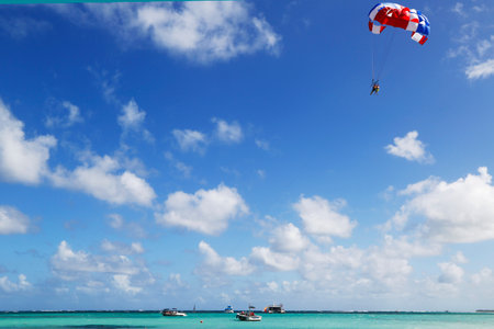 PUNTA CANA, DOMINICAN REPUBLIC - DECEMBER 31  Parasailing in a blue sky in Punta Cana on December 31, 2013  Parasailing is a popular recreational activity among tourists in Dominican Republic のeditorial素材