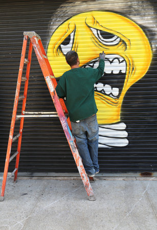 NEW YORK - JUNE 1  Street artist painting mural at Williamsburg in Brooklyn on June 1, 2014  Outdoor art gallery known as the Bushwick Collective has most diverse collection of street art in Brooklynのeditorial素材