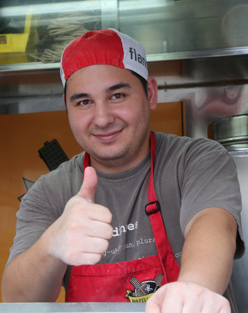 NEW YORK - SEPTEMBER 8: Unidentified worker at Wafels and Dinges cart in Central Park on September 8, 2014. Central Park is designated a National Historic Landmark in 1962 was officially opened in 1857のeditorial素材