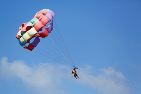 PUNTA CANA, DOMINICAN REPUBLIC - JANUARY 2, 2015: Parasailing in a blue sky in Punta Cana. Parasailing is a popular recreational activity among tourists in Dominican Republicのeditorial素材