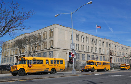BROOKLYN, NEW YORK - MARCH 19, 2015: School buses in the front of public school in Brooklyn. New York City has the largest school transportation department in the country.のeditorial素材