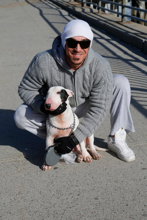 BROOKLYN, NY - MARCH 19, 2015: Unidentified man with Bull Terrier in Brooklyn. The Bull Terrier is a breed of dog in the terrier familyのeditorial素材