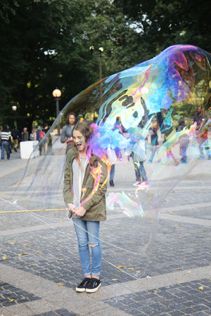 NEW YORK CITY - OCTOBER 9, 2015: Street performer creating oversize bubbles for kids at Central Park...