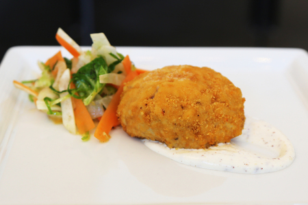 Gourmet crab cake served with sauce and saladの写真素材
