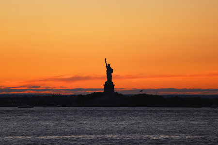 NEW YORK - AUGUST 22, 2015: The Statue of Liberty in New York Harbor at sunsetのeditorial素材