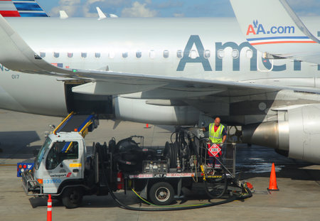 MIAMI, FLORIDA - JUNE 1, 2016: American Airlines worker refueling plane at Miami International Airport. American Airlines operates 274 flights every day from Miamiのeditorial素材
