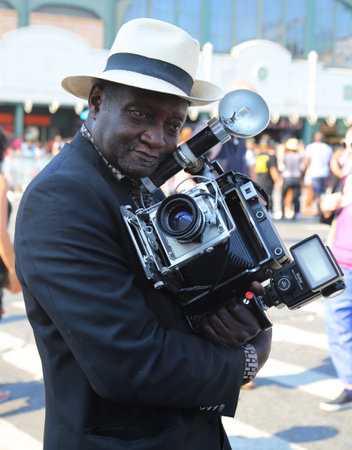 NEW YORK - JUNE 18, 2016: Unidentified photographer with vintage camera during the 34th Annual Mermaid Parade, the largest art parade in the nation and a celebration of ancient mythologyのeditorial素材