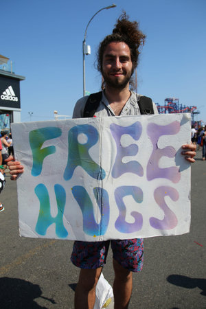 NEW YORK -JUNE 18, 2016:Young man offers free hugs at the 34th Annual Mermaid Parade, the largest art parade in the nation and a celebration of ancient mythology and honky-tonk rituals of the seaside.のeditorial素材