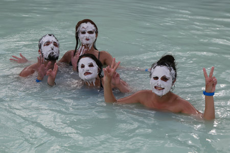 ICELAND - JULY 5, 2016: Geothermal spa visitors with silica mud masks relax and refresh at the famous Blue Lagoon in Icelandのeditorial素材