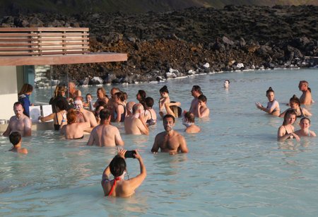 ICELAND - JULY 5, 2016: Geothermal spa visitors with silica mud masks relax and refresh at the famous Blue Lagoon in Icelandのeditorial素材