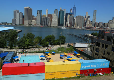 NEW YORK - JULY 21, 2016: Panoramic view of Manhattan and Pier 2 Pop-Up Pool in Brooklyn Bridge Park in Brooklyn.のeditorial素材