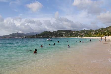 GRAND ANSE BEACH, GRENADA - JUNE 10, 2017: Local residents enjoy sunny day at Grand Anse Beach in Grenada.のeditorial素材