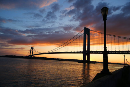 NEW YORK - JULY 15, 2017: Verrazano Bridge at sunset in New York.The Verrazano Bridge is a double-decked suspension bridge that connects the boroughs of Staten Island and Brooklynのeditorial素材