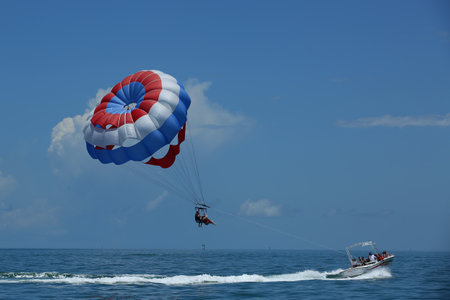 KEY WEST, FLORIDA  - MAY 31, 2016: Parasailing in a blue sky in Key West. Parasailing is a popular recreational activity among tourists in Key Westのeditorial素材