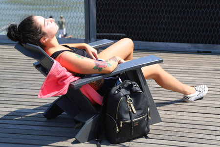 NEW YORK - MAY 3, 2018: Young woman  enjoys a sunny day in South Street Seaport, Lower Manhattan