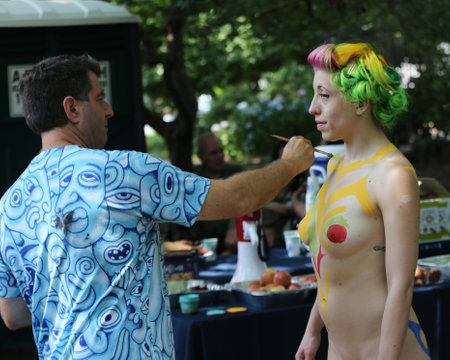 NEW YORK - JULY 14, 2018: Artists paint  fully nude models of all shapes and sizes during 5th NYC Body Painting Day featuring artist Andy Golub on Washington Square in New Yorkのeditorial素材