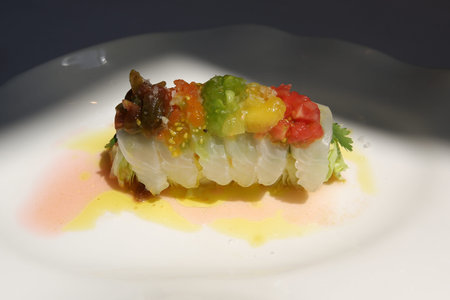 Seafood appetizer in gourmet French restaurant. Madai Sashimi with Iceberg Lettuce, Cherry Tomato...