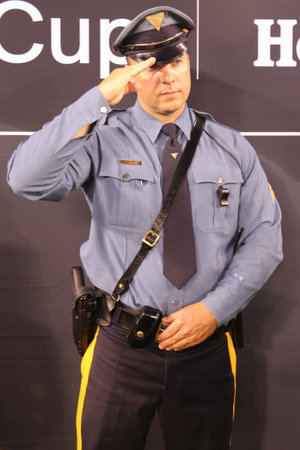 EAST RUTHERFORD, NJ - AUGUST 7, 2018: New Jersey State Police officer salutes during American Anthem...