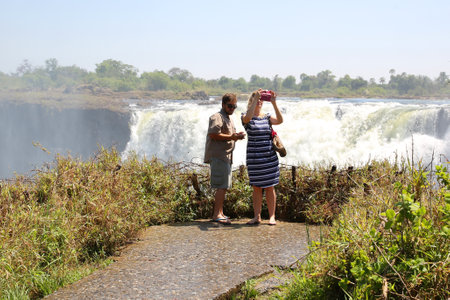HWANGE, ZIMBABWE - OCTOBER 3, 2018: Tourists at the Victoria Falls National Park. Park located at the south and east bank of the Zambezi River in the area of the world-famous Victoria Fallsのeditorial素材