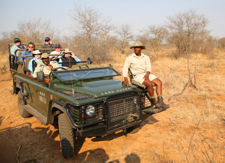 HOEDSPRUIT, SOUTH AFRICA - SEPTEMBER 28, 2018: Tourists in safari vehicle with safari ranger and spotter in Timbavati Private Nature Reserve, South Africaのeditorial素材
