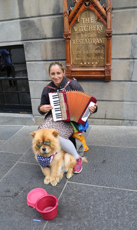 EDINBURGH, SCOTLAND - JULY 7, 2018: Street musician with dog  in Edinburgh, Scotlandのeditorial素材