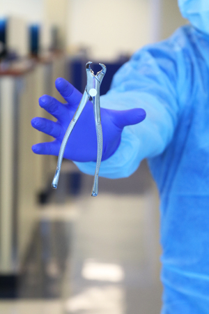 Oral surgeon with extraction forcepsの写真素材