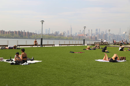 BROOKLYN, NEW YORK - MAY 2, 2019: Tourists and New York locals alike enjoy a sunny day in Domino...