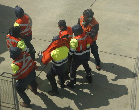 PUNTA ARENAS, CHILE - JANUARY 30, 2020: Airport workers help passengers disembark Latam Airlines...