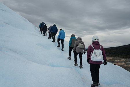 EL CALAFATE, ARGENTINA - FEBRUARY 9, 2020: A group of crampons wearing tourists trekking on Perito Moreno Glacier in the Los Glaciares National Park in southwest Santa Cruz Province, Argentinaのeditorial素材