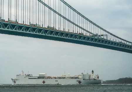 NEW YORK - APRIL 30, 2020:  The USNS Comfort Hospital Ship leaves New York Harbor and sails under the Verrazzano-Narrows Bridge after a month of caring for patients with the Coronavirusのeditorial素材