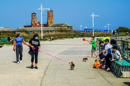 QUEENS, NEW YORK - MAY 14, 2020: Woman wears t-short promoting social distancing enjoying outdoors during Coronavirus pandemic at Jacob Riis Park promenade in Queens, New Yorkのeditorial素材