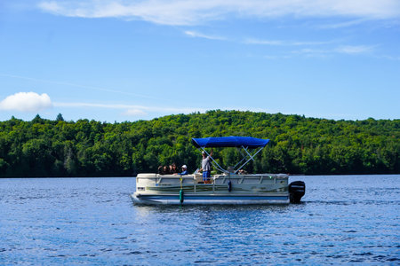 LAKE PLACID, NEW YORK - AUGUST 20, 2020: Boaters on pontoon boat enjoy summer day on Lake Placid in...