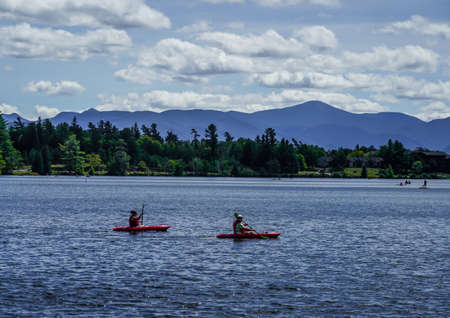 LAKE PLACID, NEW YORK - AUGUST 20, 2020: Kayakers enjoy summer day on Mirror Lake in Lake Placid, New York Stateのeditorial素材