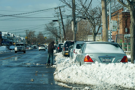 BROOKLYN, NEW YORK - DECEMBER 17, 2020: Man shoveling snow from street in Brooklyn, NY after massive Winter Storm Gailのeditorial素材