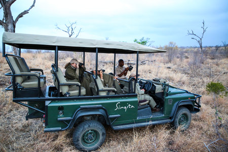 HAZYVIEW, SOUTH AFRICA - SEPTEMBER 30, 2018: Tourists in safari vehicle observing African leopard in Sabi Sands Game Reserve, South Africaのeditorial素材