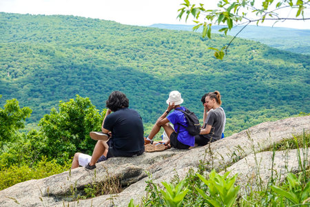 BEAR MOUNTAIN, NEW YORK - JUNE 21, 2020: Hikers enjoy Hudson Valley view at the summit of Bear...