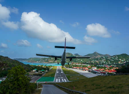 ST. BARTS, FRENCH WEST INDIES - FEBRUARY 4, 2021: Plane landing at Remy de Haenen Airport also known as Saint Barthelemy Airport. At 2,133 ft its runway is one of the shortest in the worldのeditorial素材