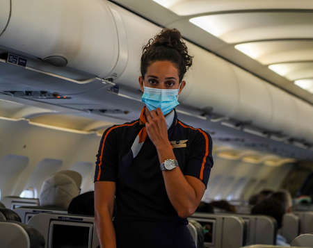 QUEENS, NEW YORK - AUGUST 7, 2021: Jet Blue flight attendant demonstrating the use of an oxygen mask during a pre-flight safety demonstrationのeditorial素材