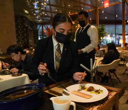 NEW YORK - AUGUST 26, 2021: Server plates fish dish at the Two Star Michelin and Relais & Chateaux award-winning Gabriel Kreuther restaurant sign in Midtown Manhattanのeditorial素材