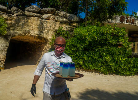 PLAYA DEL CARMEN, MEXICO - JULY 6, 2021: Bartender serves customers at the Hotel Xcaret Mexico in Playa del Carmen, Mexico. It is sophisticated hotel that surpasses the traditional All-Inclusive hotelのeditorial素材